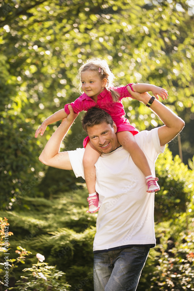 Fototapeta premium Vater trägt Tochter auf den Schultern