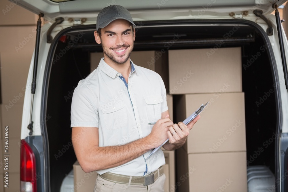Delivery driver smiling at camera beside his van Delivery driver smiling at camera beside his van