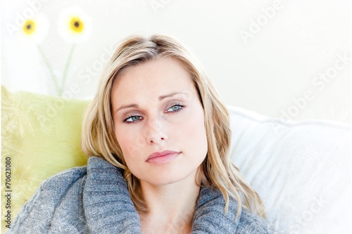 Exhausted woman lying on the sofa with a grey pullover