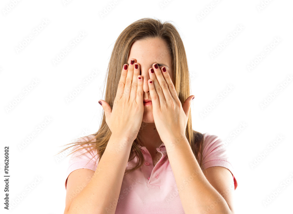 Girl covering her eyes over isolated white background Girl covering her eyes over isolated white background
