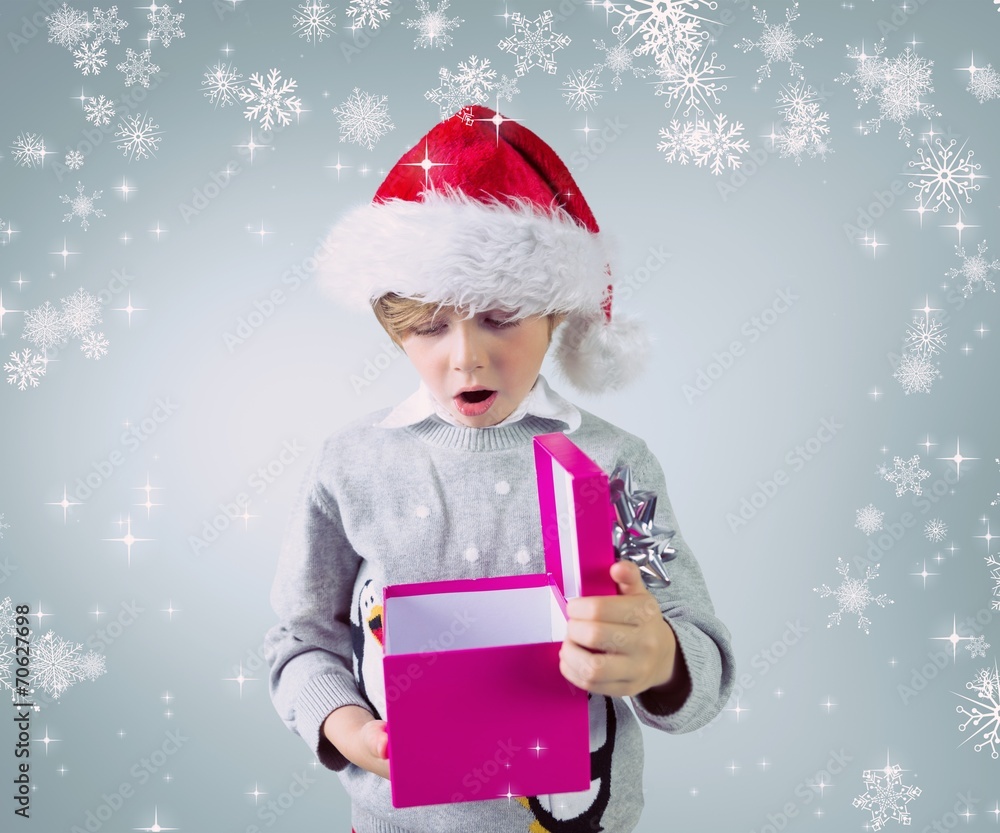 Composite image of cute festive boy opening present Composite image of cute festive boy opening present