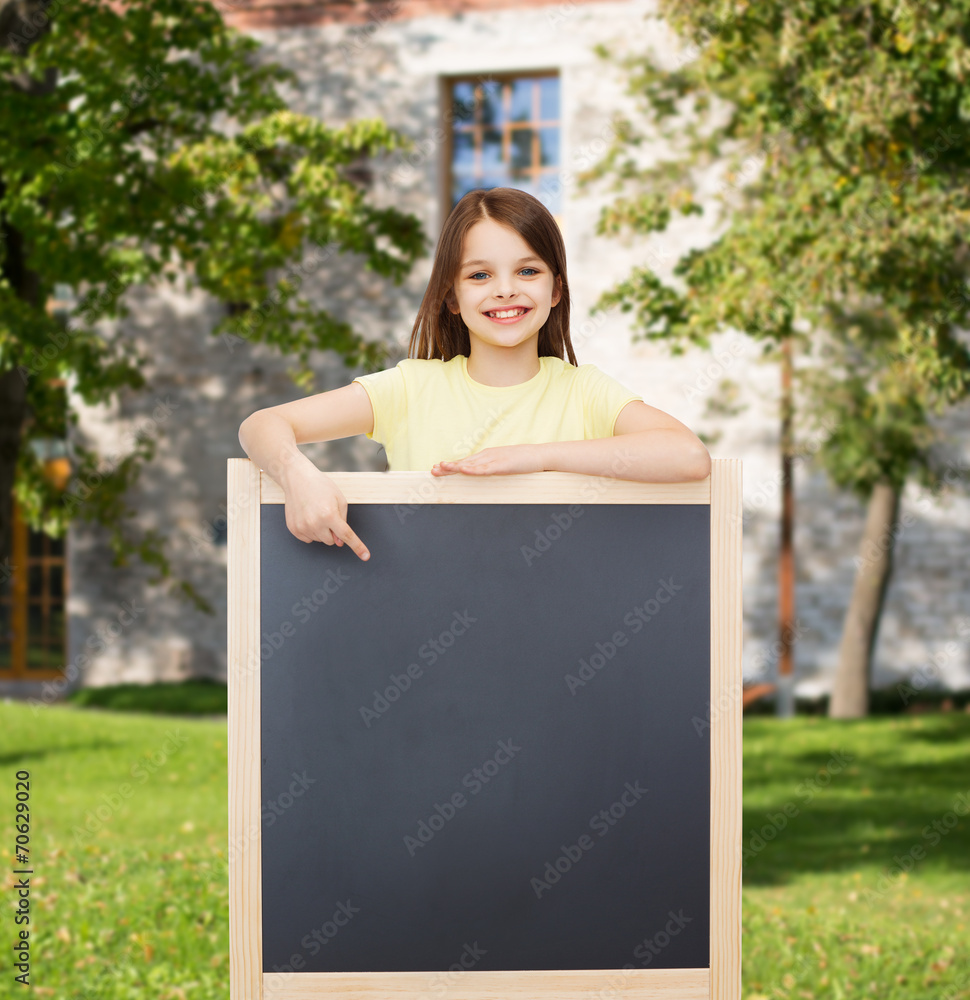 happy little girl pointing finger to blackboard happy little girl pointing finger to blackboard