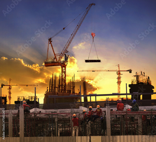 worker working in high building construction site against beauti