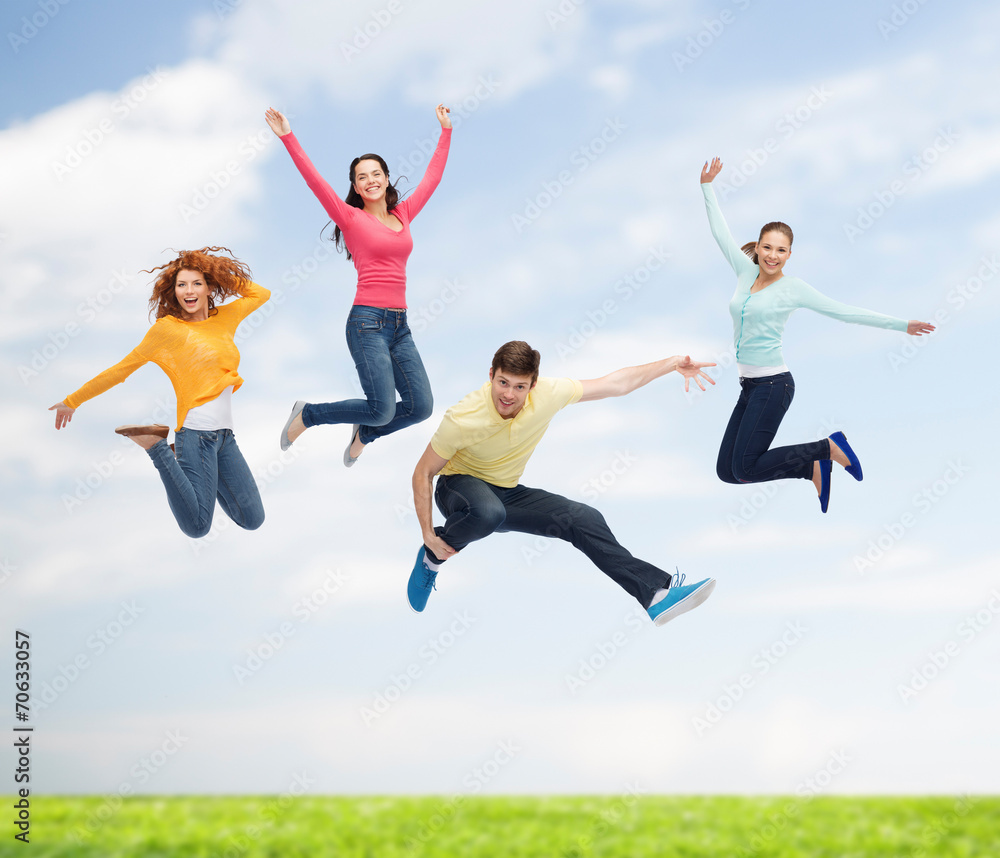 group of smiling teenagers jumping in air group of smiling teenagers jumping in air