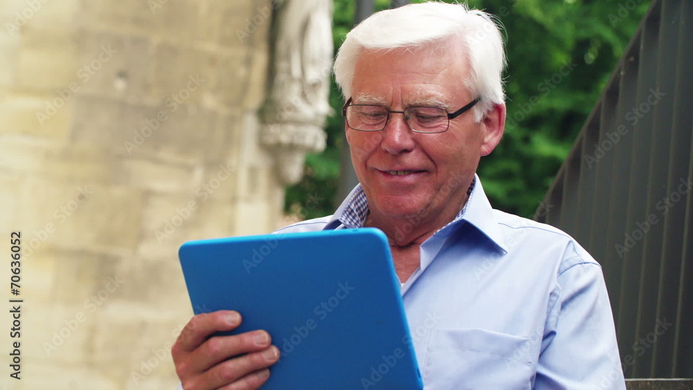 Senior man using tablet pc and smiling Senior man using tablet pc and smiling