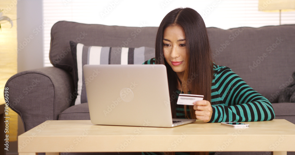 Japanese woman typing in credit card information Japanese woman typing in credit card information