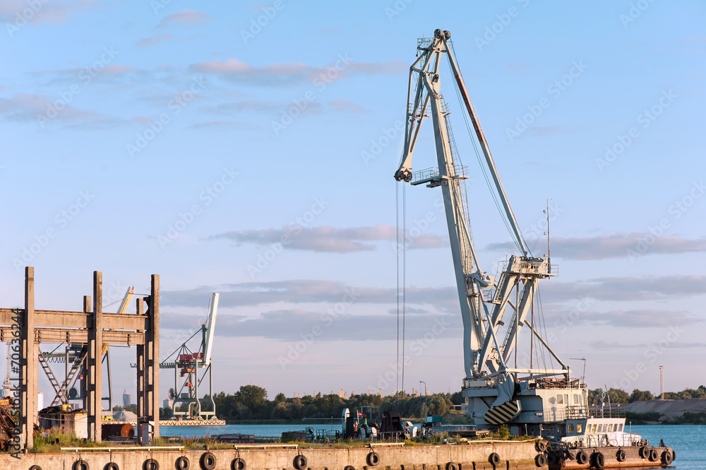 Floating cargo crane on barge near quay. Mooring in Riga.