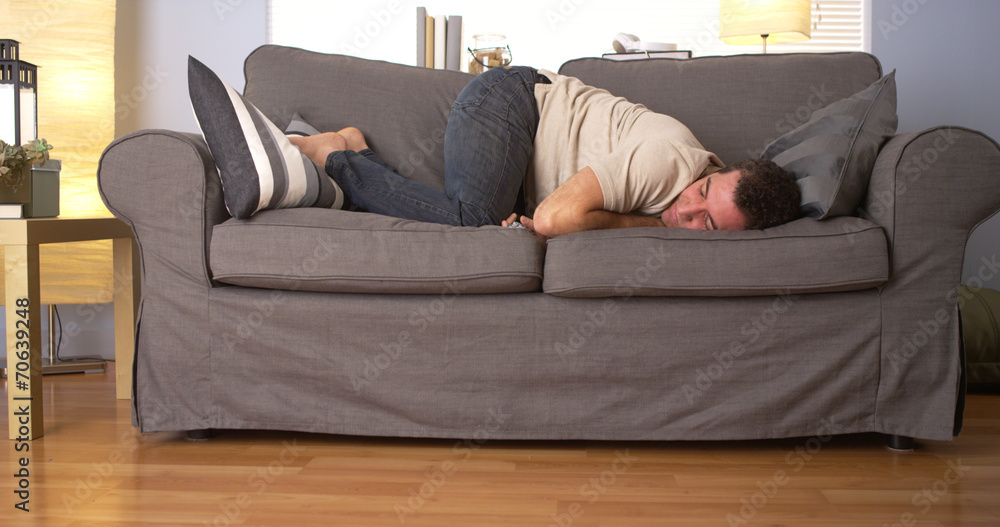 Man trying to sleep on couch Stock Photo Adobe Stock