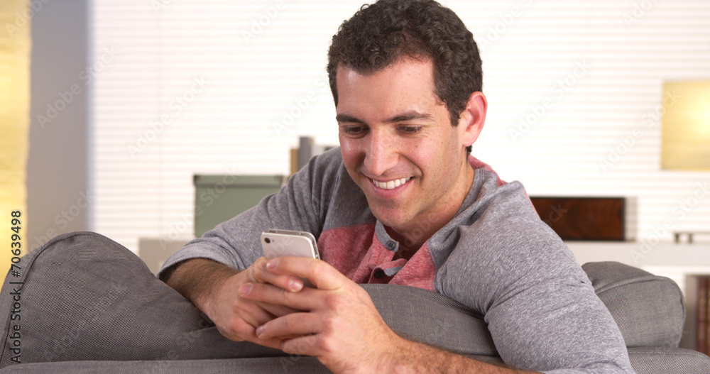 Fototapeta premium Man happily texting on smartphone