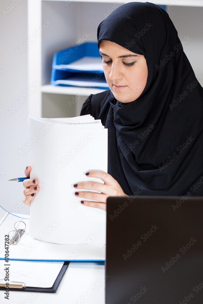 Muslim female office worker doing paperwork Muslim female office worker doing paperwork