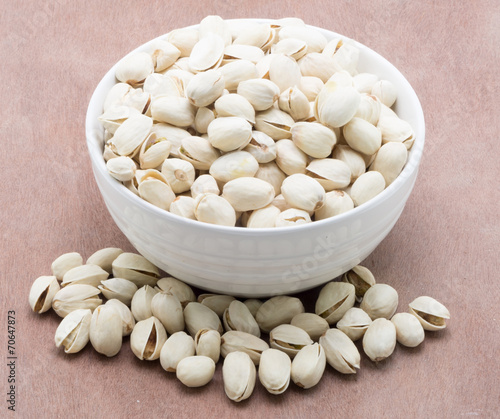 Pistachio nuts on wooden surface