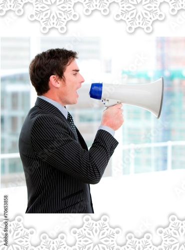 Frustrated businessman yelling through a megaphone photo