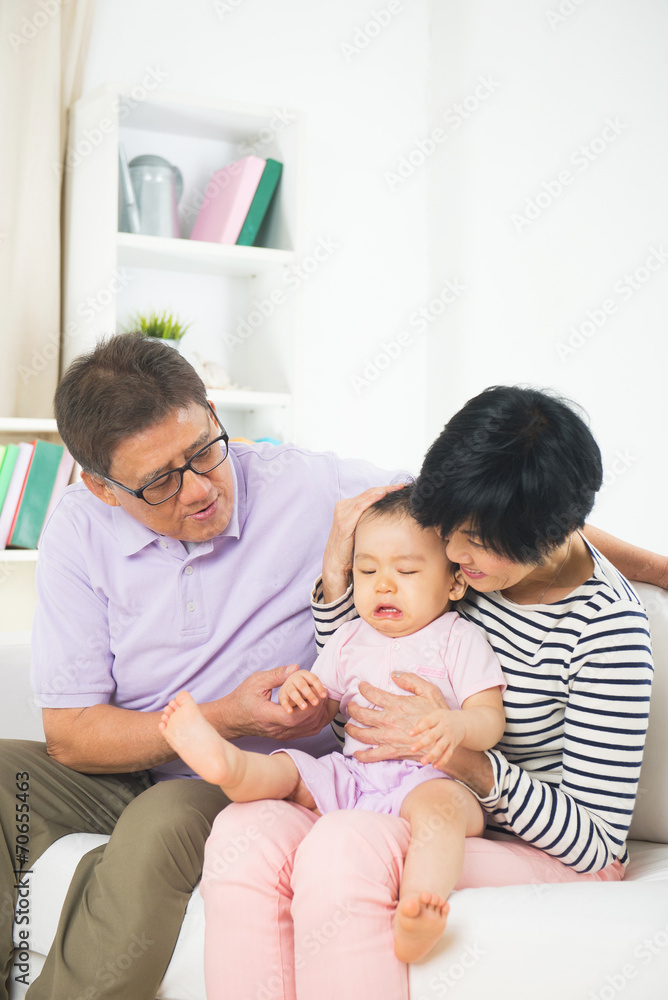 asian grand parents comforting their spoilt crying grand daugthe asian grand parents comforting their spoilt crying grand daugthe