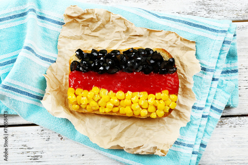 Sandwich with flag of Germany on table close-up