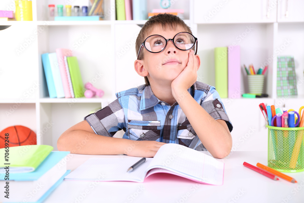 Schoolboy sitting at table in classroom Schoolboy sitting at table in classroom