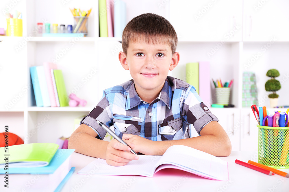 Schoolboy sitting at table in classroom Schoolboy sitting at table in classroom