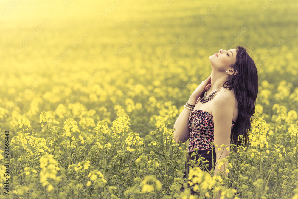 Beautiful woman in meadow of yellow flowers with head up Beautiful woman in meadow of yellow flowers with head up