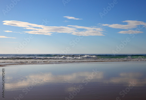Wolken spiegeln sich am Strand © buellom