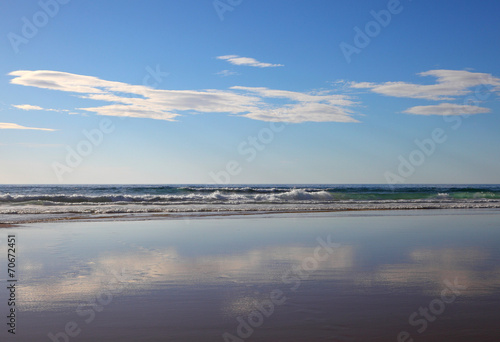 Wolken spiegeln sich am Strand