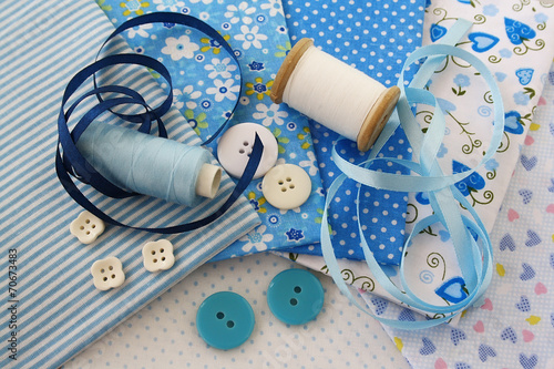 Accessories for sewing: threads, fabric, buttons in blue-white c