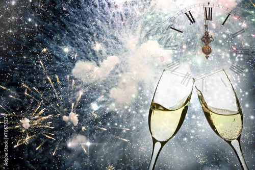 Glasses with champagne against fireworks and clock