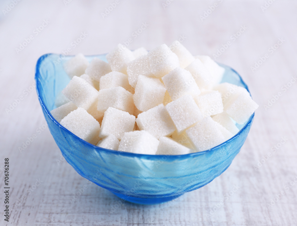 Refined sugar in color bowl on wooden background Refined sugar in color bowl on wooden background