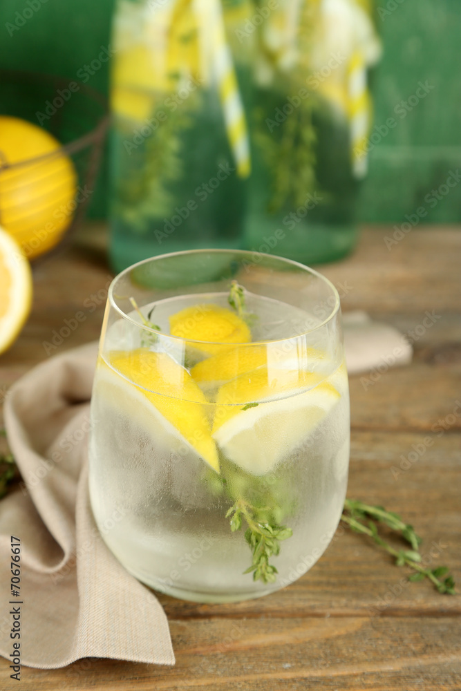 Tasty cool beverage with lemon and thyme, on wooden background Tasty cool beverage with lemon and thyme, on wooden background