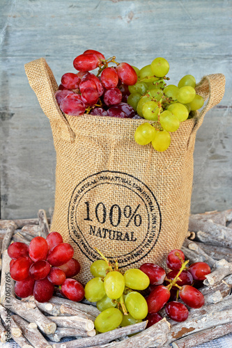 Natuurlijke tros rode en groene druiven in jute zak photo
