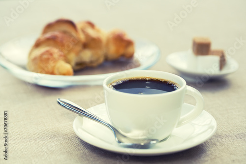 Breakfast with cup of black coffee and croissant