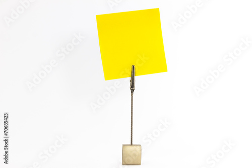 Paperclip holds yellow sticky note