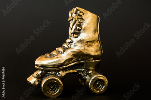 Obraz na płótnie golden roller skate against black background