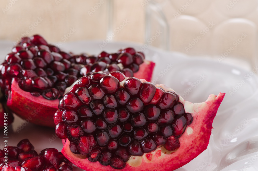 Closeup sliced pomegranate on white plate Closeup sliced pomegranate on white plate