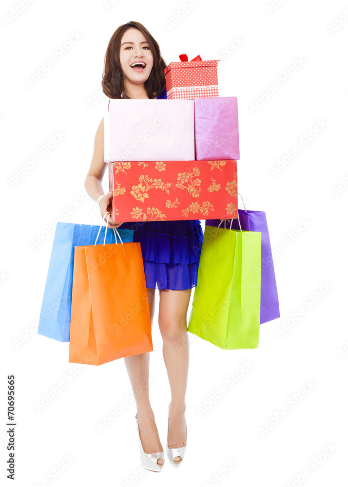 smiling young woman holding shopping bag and a gift box