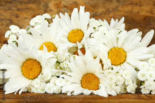 Beautiful chamomiles on wooden background