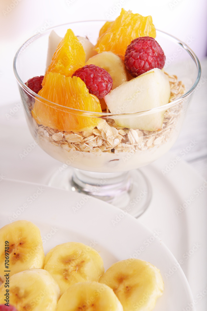 Muesli with fruits and berries on table on bright background Muesli with fruits and berries on table on bright background