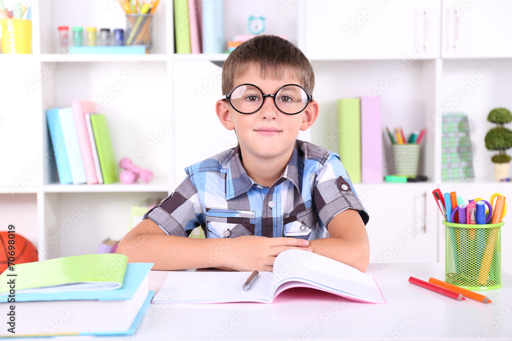Schoolboy sitting at table in classroom Schoolboy sitting at table in classroom