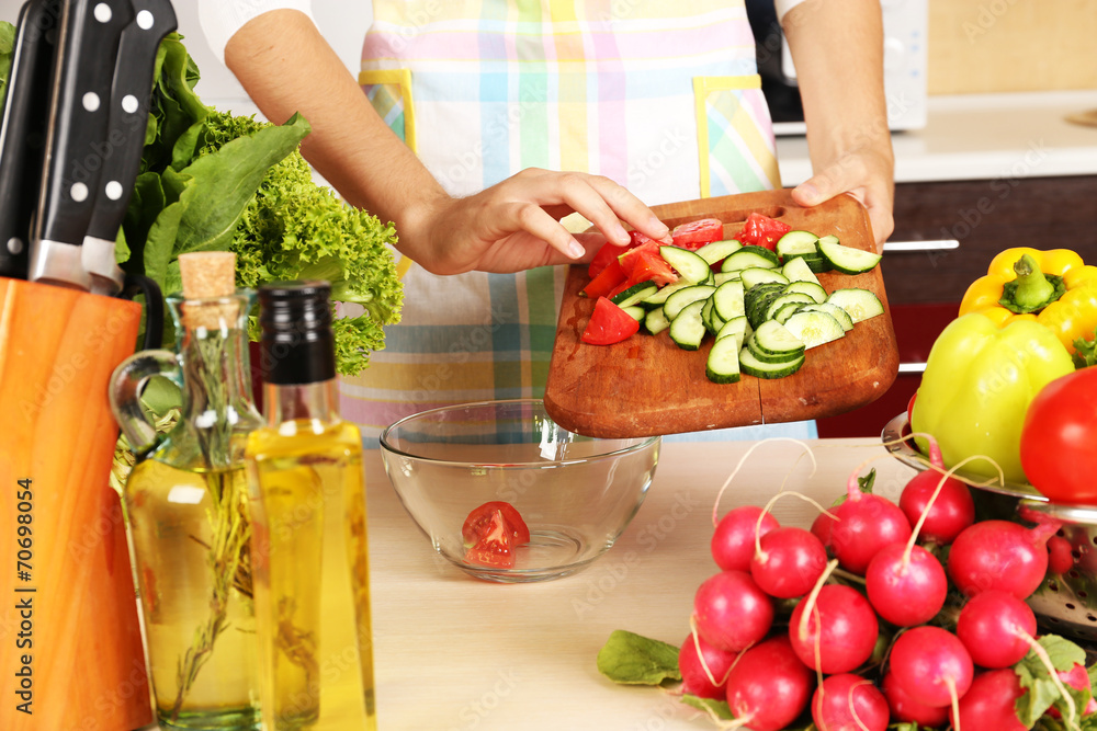 Woman cooking vegetable salad in kitchen Woman cooking vegetable salad in kitchen