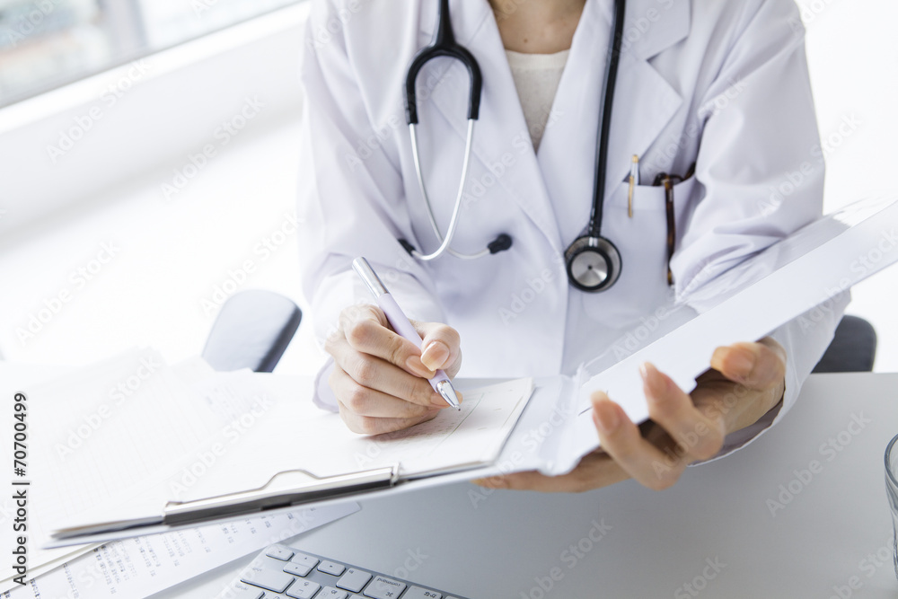 Fototapeta premium Female doctor writing a medical certificate