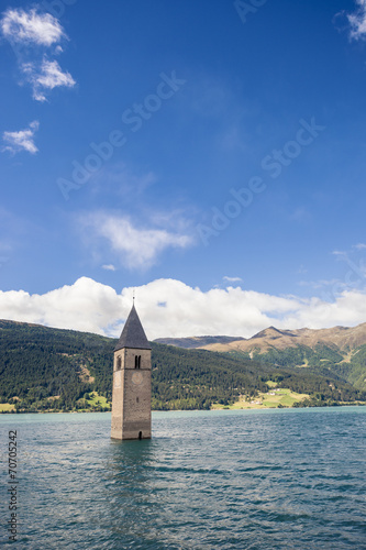 sunken church tower in lake in the alps