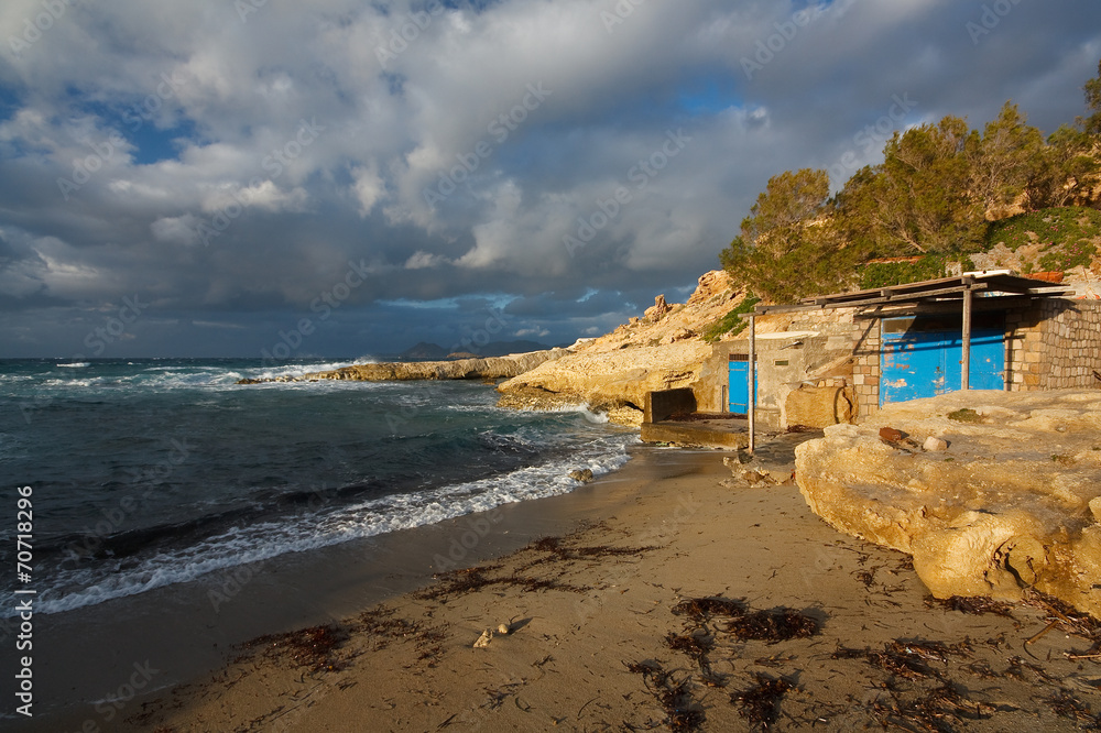 Boat houses on a beach in Milos island, Cyclades, Greece.