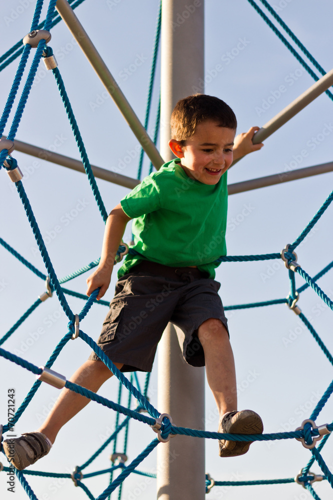 Kid having fun on the jungle gym at the park Kid having fun on the jungle gym at the park
