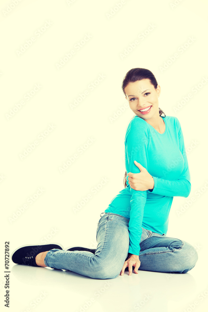 Young woman in casual clothes sitting on floor Young woman in casual clothes sitting on floor