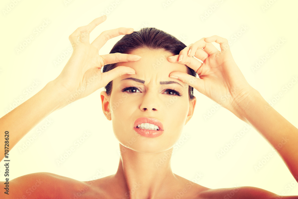 Woman checking her wrinkles on her forehead Woman checking her wrinkles on her forehead