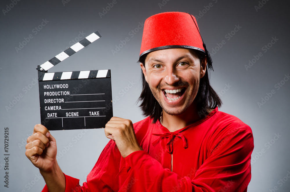 Man wearing fez hat with movie board Man wearing fez hat with movie board