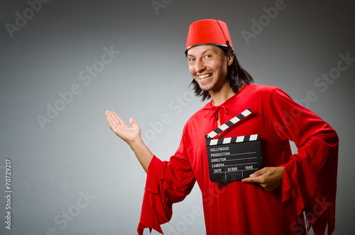 Man wearing fez hat with movie board photo