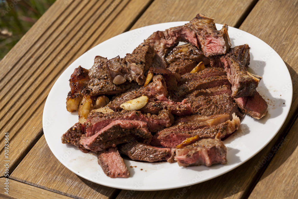 Plate of Grilled Steak and Garlic with Red Napkin Plate of Grilled Steak and Garlic with Red Napkin