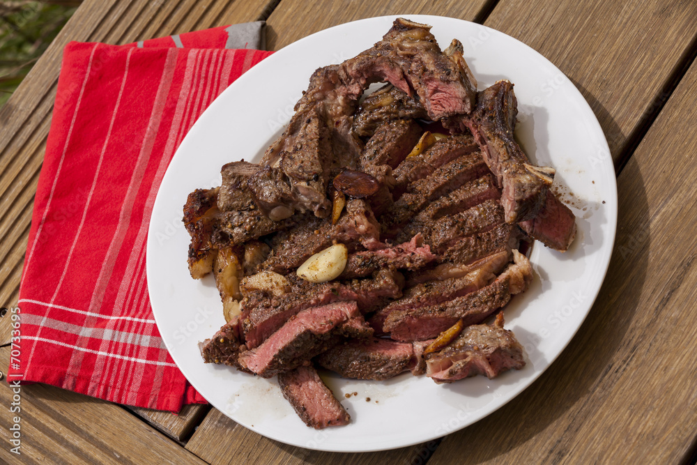 Plate of Grilled Steak and Garlic with Red Napkin Plate of Grilled Steak and Garlic with Red Napkin