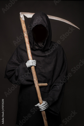 Angel of death with a scythe in his hands on black background