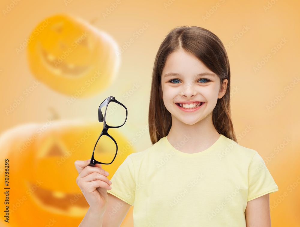 smiling girl in glasses over pumpkins background smiling girl in glasses over pumpkins background