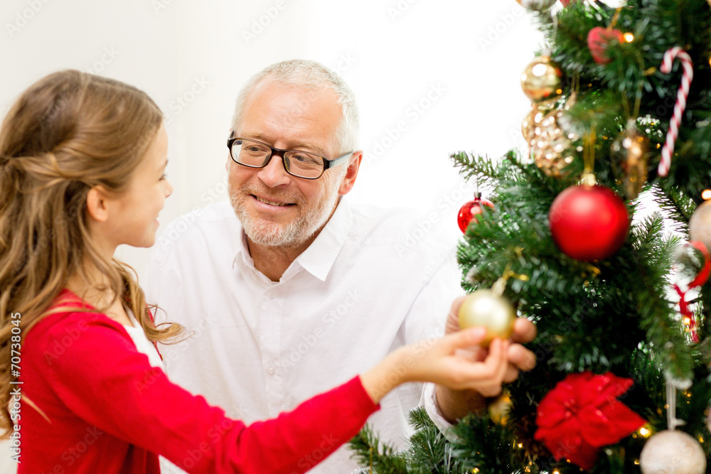 smiling family decorating christmas tree at home